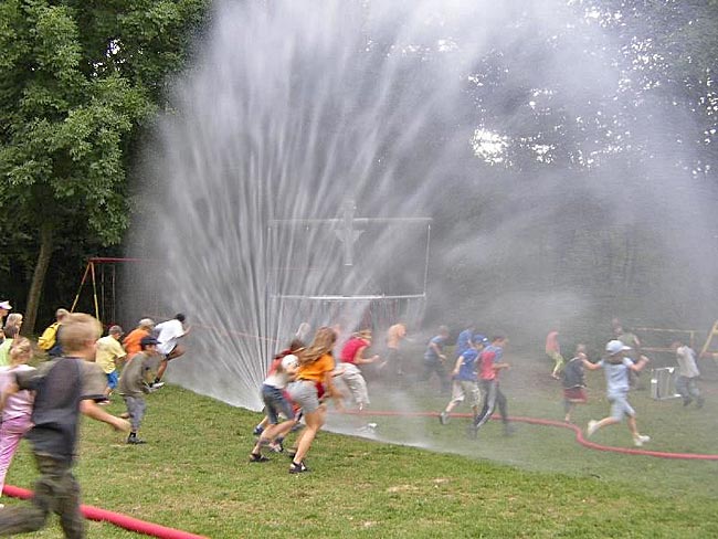 Bild: Kinder rennen durch eine Wasserfontäne 